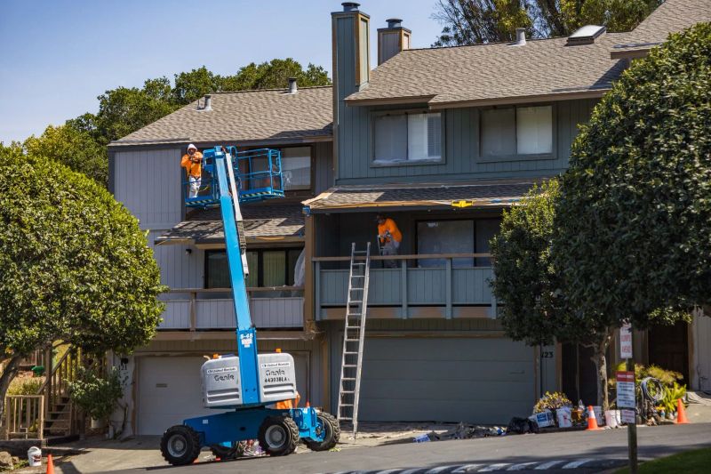 Residential siding being gently soft washed to remove algae and exterior buildup