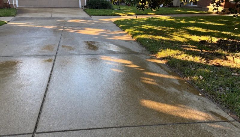 Residential driveway showing a noticeably cleaner surface after pressure washing
